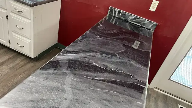 Countertop in black, white and red marble-look epoxy against a red wall