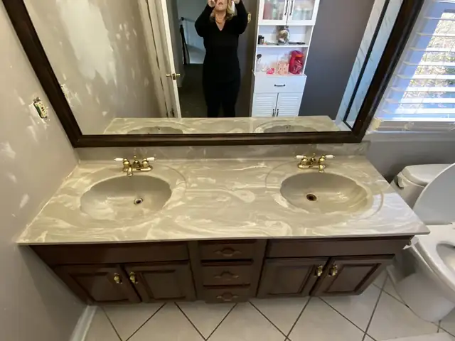 Spare bathroom double vanity with cream marble-look epoxy top and large framed mirror